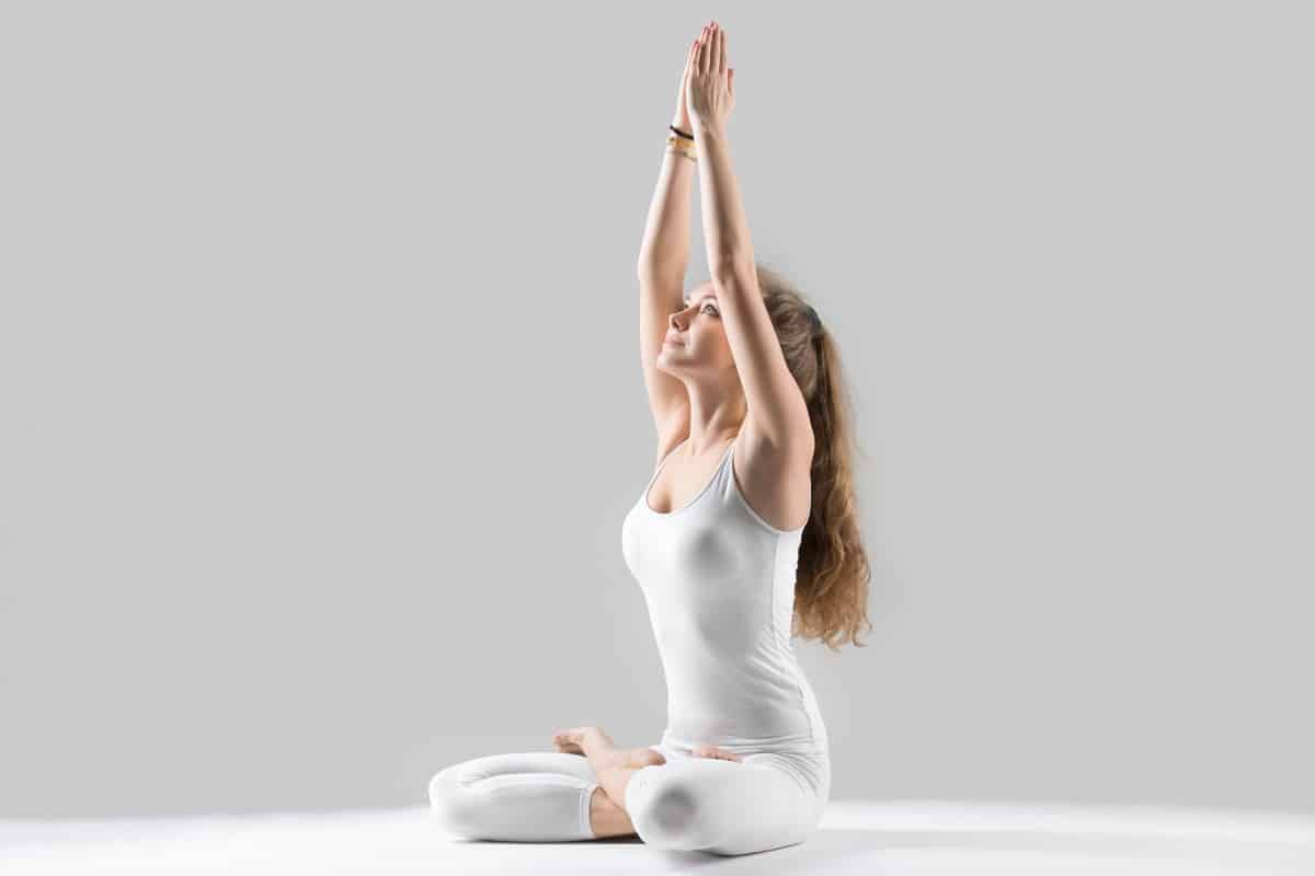 young attractive woman sitting padmasana pose grey studio ba 1
