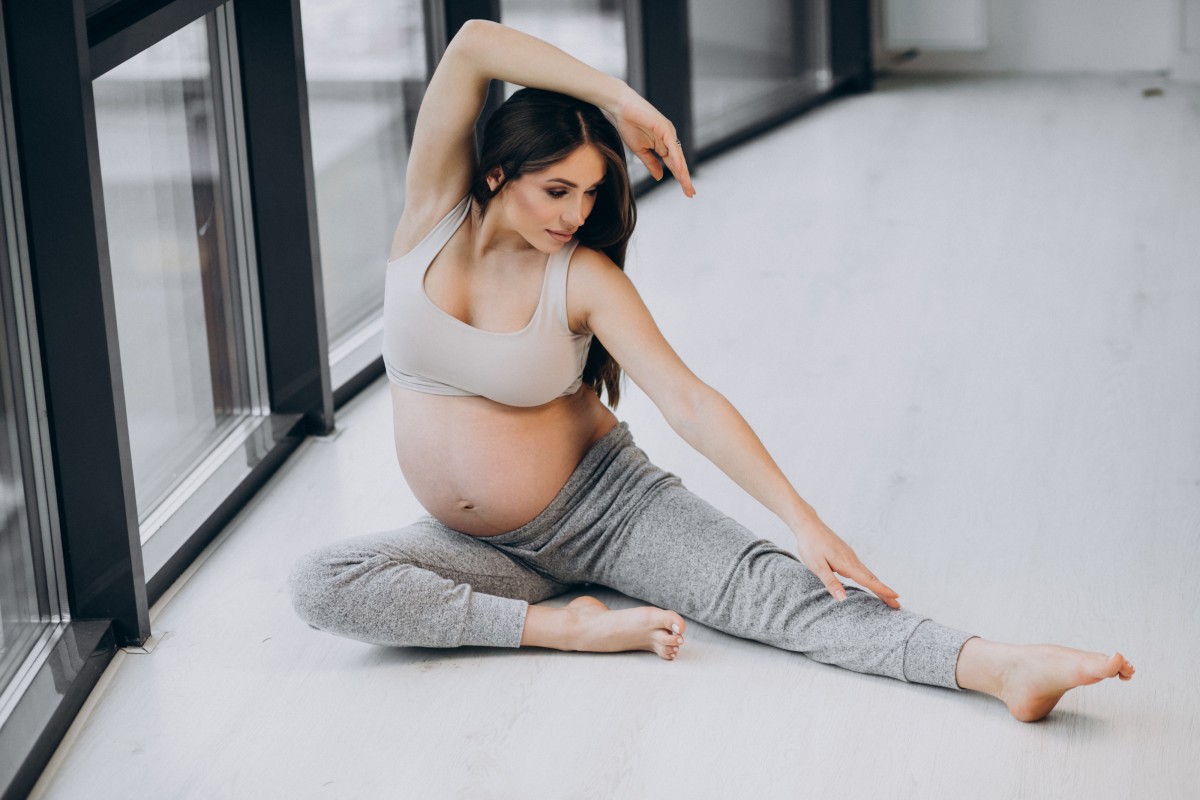 pregnant woman practising yoga home by window 1